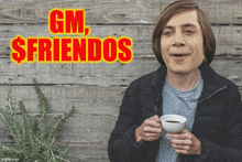 a man is holding a cup of coffee in front of a sign that says gm friends