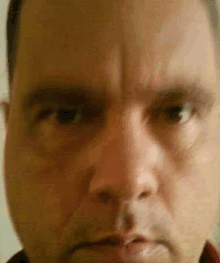 a close up of a man 's face with a very angry expression .