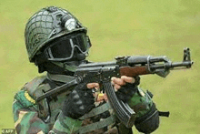 a soldier is wearing a helmet and goggles and holding a gun .