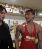 a man wearing a red tank top that says яззи on it