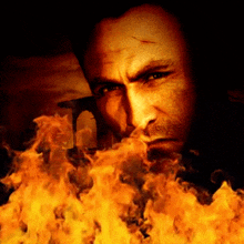 a close up of a man 's face with flames coming out of his mouth