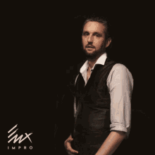 a man wearing a leather vest and a white shirt is standing in front of a black background that says imx improv