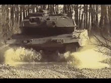 a tank is driving down a dirt road in the middle of a forest .