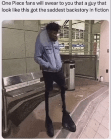 a man with very long legs is standing next to a trash can and a bench