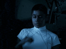 a woman in a white shirt is looking at the camera