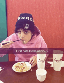 a person sitting at a table with a plate of food and a cup that says " first date kinda nervous " on it