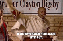 a man is standing at a podium in front of a brick wall holding a bat and a bible .