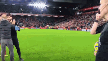 a group of people standing on a soccer field in front of a crowd with a sign that says ' manchester united '