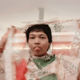 a woman sticking her tongue out while wearing a scarf