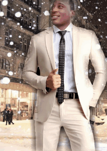 a man in a suit and tie stands in front of a snowy building