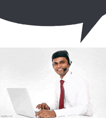 a man wearing a headset sits in front of a laptop computer