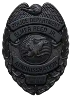 a black badge that says police department elmer reed jr.