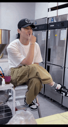 a man sitting on a stool in front of a refrigerator that says evaporator