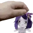 a hand is putting a stuffed doll on top of another stuffed doll with purple hair .