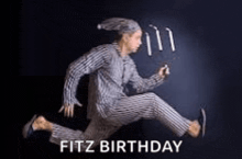 a man in pajamas is jumping in the air while holding a candle .