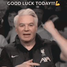 a man wearing a black shirt that says ' axa ' on it is giving a thumbs up