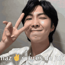 a man giving a peace sign with the words haz si eres de juli written below him