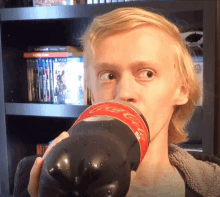 a man drinking from a coca cola bottle