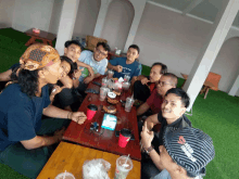 a group of men are sitting around a table with drinks on it