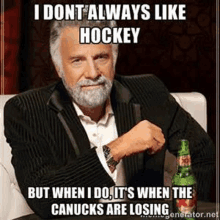 a man with a beard is sitting at a table with a bottle of beer and a hockey meme .