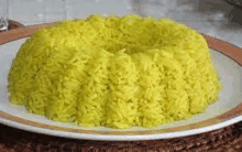 a plate of yellow rice is sitting on a place mat on a table .