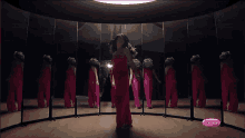 a woman in a red dress is dancing in front of a mirror with a pink button that says aotima on it