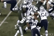 a group of football players are playing a game of football on a field .
