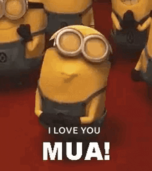 a group of minions are standing next to each other on a red carpet and one of them is wearing goggles .
