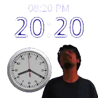 a man is standing in front of a clock that says 8:20 pm