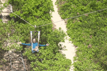 a person is flying through the air on a ropes course