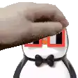 a hand is touching a penguin with glasses and a bow tie .