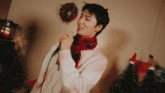 a man singing into a microphone in front of a wreath
