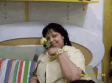 a woman in a yellow shirt is holding a yellow rose in her hand and the date 05/02/2011