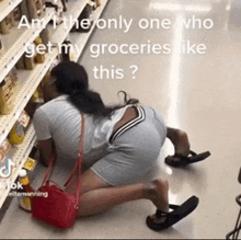 a woman is crawling on the floor in a grocery store