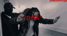 a man in a black jacket with the word " doa " on his chest