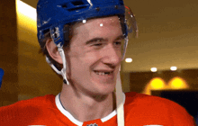 a hockey player wearing a blue helmet and a red shirt