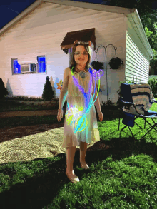 a little girl in a white dress is standing in front of a house