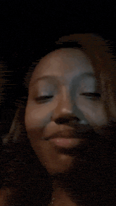 a close up of a person 's face with a black background