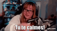 a woman wearing glasses and headphones is sitting in front of a microphone and says `` tu te calmes '' .