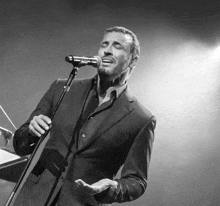 a man singing into a microphone with his eyes closed