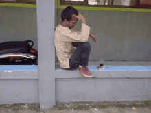 a man sits on a ledge next to a yamaha motorcycle