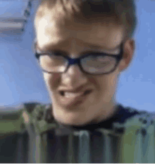 a boy wearing glasses is making a funny face .