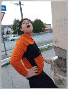 a boy with his mouth open stands in front of a sign that says left