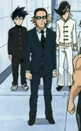 a man in a suit and tie is standing in a hallway with a group of people