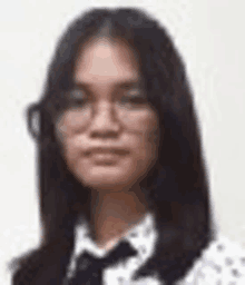 a woman wearing glasses and a bow tie is standing in front of a white background .