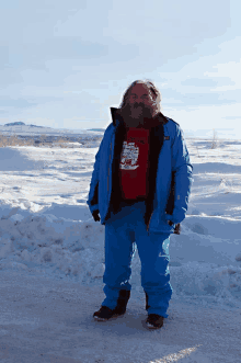 a man wearing a blue jacket and a red shirt that says ' arctic explorer '