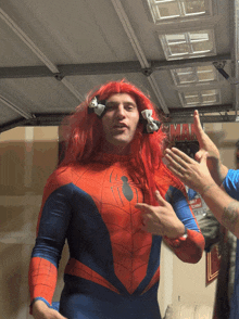 a man in a spiderman costume with red hair and bows on his ears