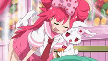 a girl in a pink dress is hugging a rabbit in a room .