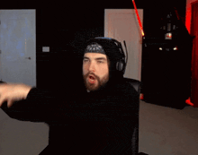 a man in a black hoodie is holding a red light stick