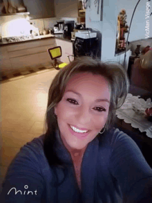 a woman is smiling and taking a selfie in a kitchen